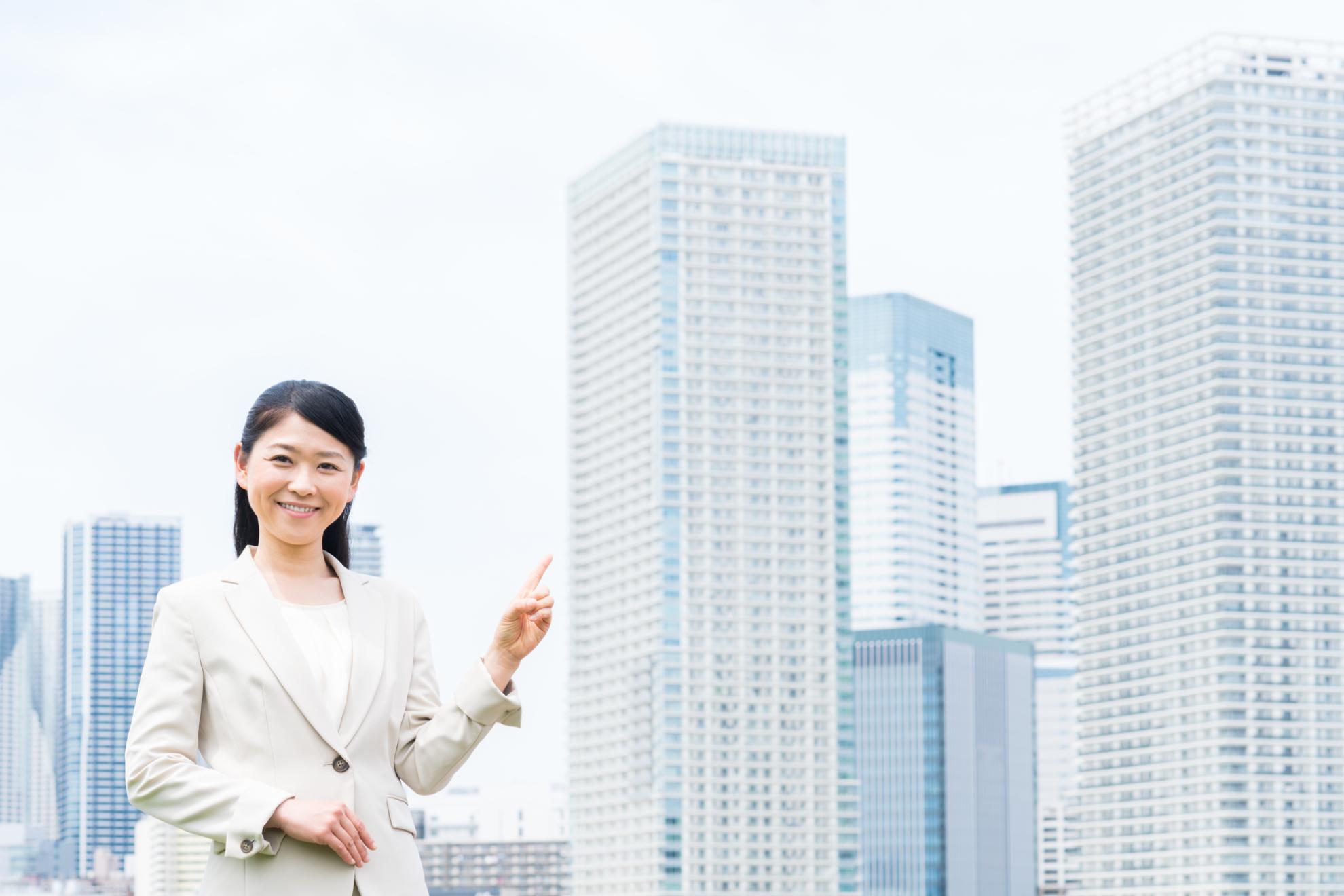 高層マンションを指す女性