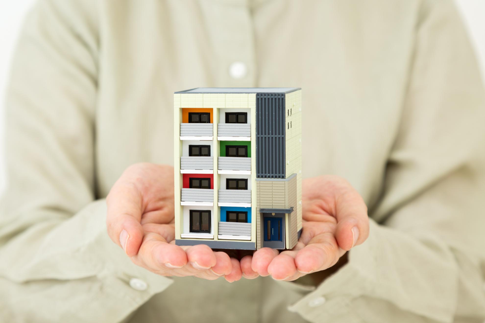 マンションのミニチュアを持った人の手元