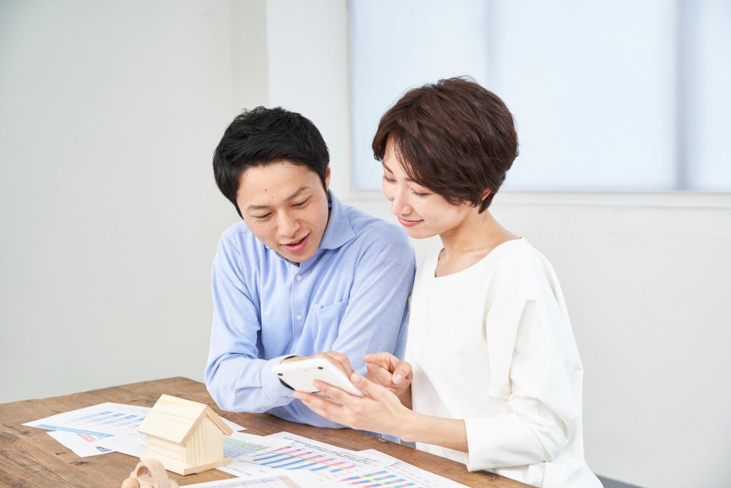 電卓でシミュレーションを行なう夫婦