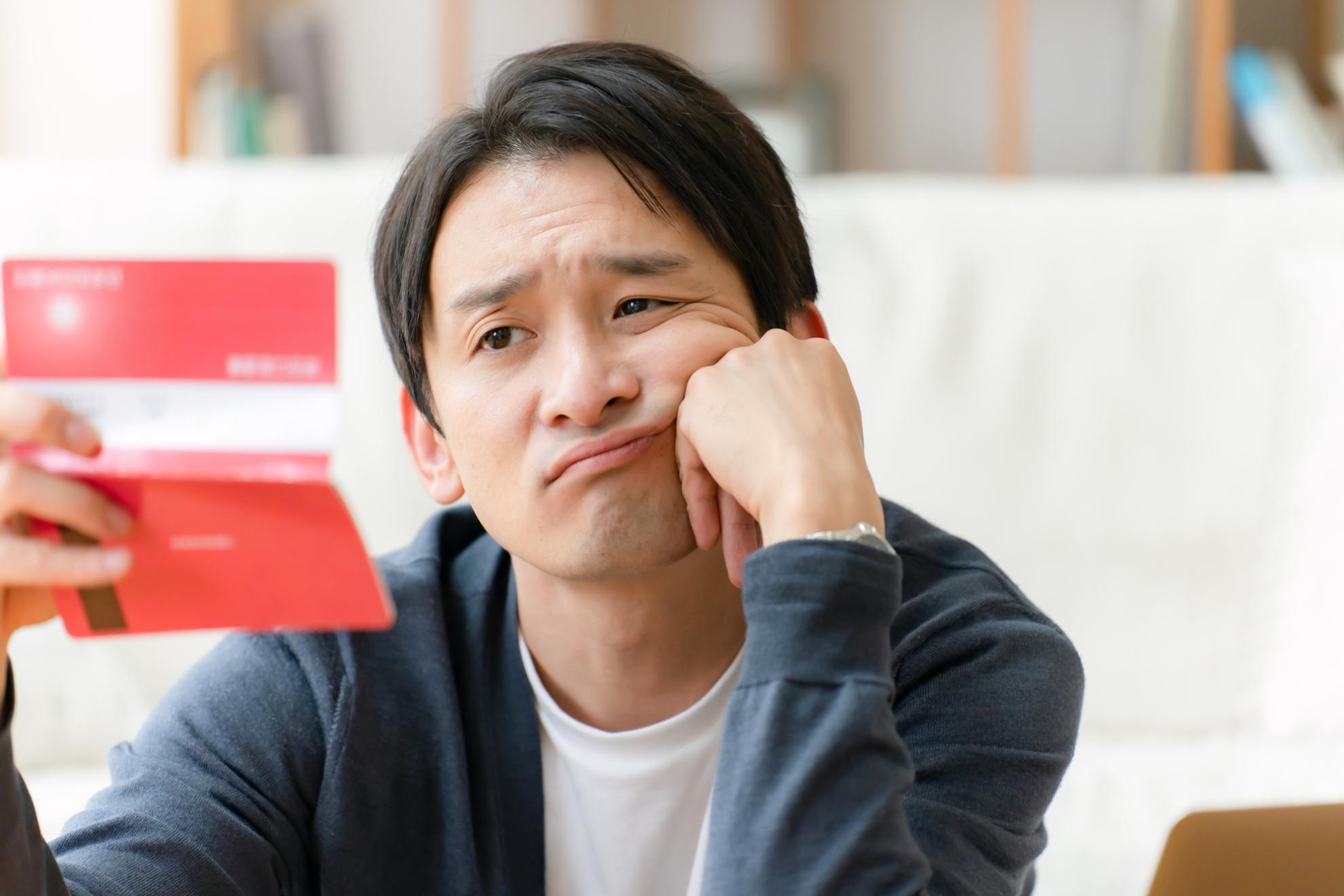 通帳を眺める男性